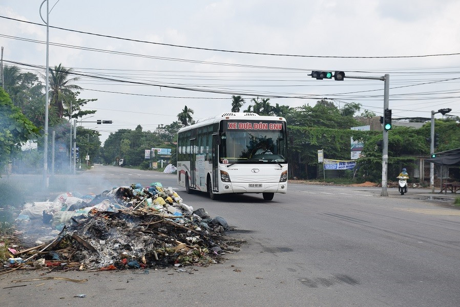 Người dân đốt rác thải tại tuyến quốc lộ 40B đoạn qua phường Trường Xuân (TP.Tam Kỳ). Ảnh: THANH THẮNG