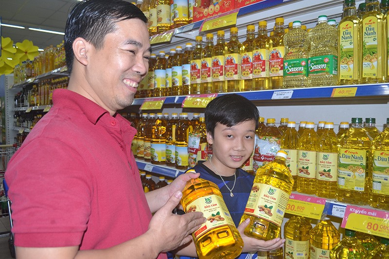 Sản xuất dầu thực vật nguyên chất của HTX Bảo Tâm (Tam Kỳ) có mặt ở siêu thị Co.opmart. Ảnh: VIỆT NGUYỄN