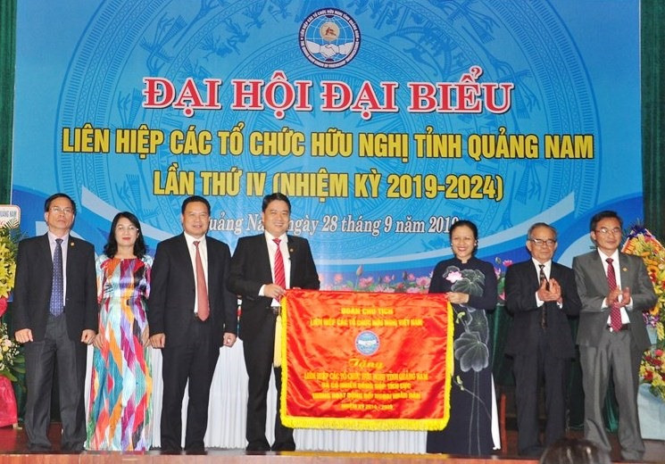 Bà Nguyễn Phương Nga - Chủ tịch Liên hiệp Các tổ chức hữu nghị Việt Nam trao tặng đại hội bức trướng. Ảnh: VINH ANH