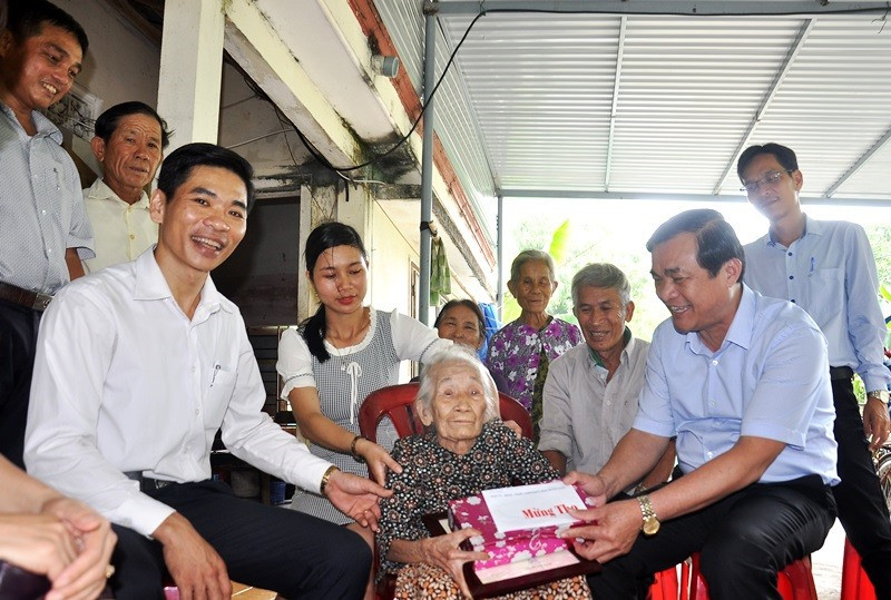 Đồng chí Phan Việt Cường và lãnh đạo địa phương tặng quà cho cụ Trịnh Thị Tuất. Ảnh: VINH ANH