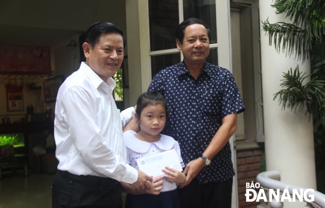 Trưởng ban Tuyên giáo Thành ủy Trần Đình Hồng (trái) trao học bổng tiếp sức đến trường đợt 2 cho em Ngô Khánh Phương Linh.