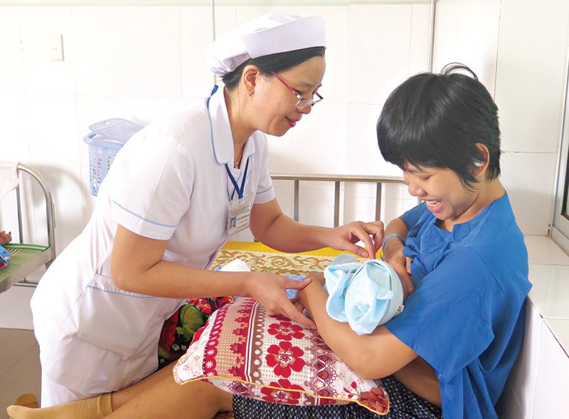 Tư vấn và hỗ trợ sản phụ trong việc cho bé bú sau sinh luôn được đội ngũ nữ hộ sinh, y tá Khoa Phụ sản BVĐK Quảng Nam chú trọng. Ảnh: X.H
