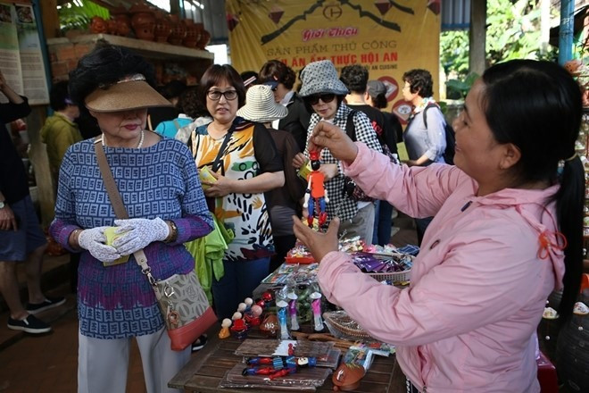 Tourists at a souvenir shop in Thanh Ha village. Photo: CAND