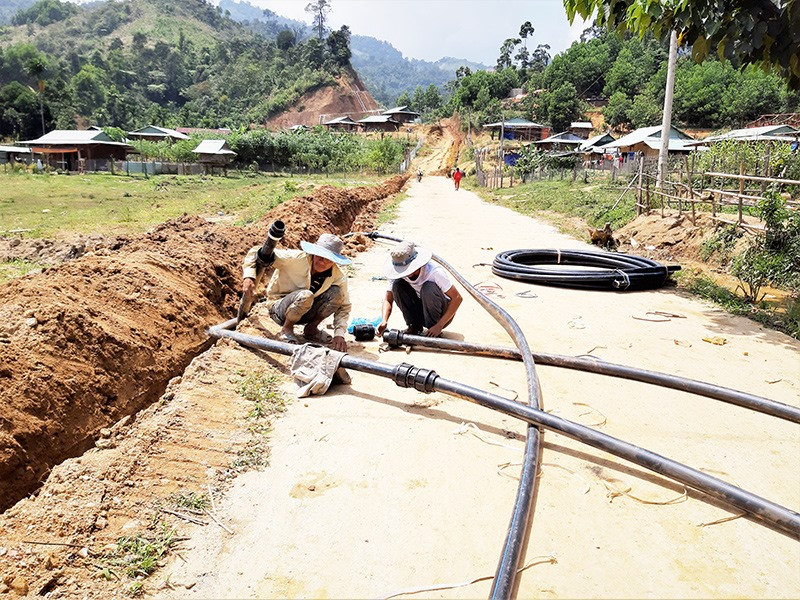 Các công nhân đang gấp rút thi công đường ống dẫn nước về khu dân cư Khe Chữ. Ảnh: T.T