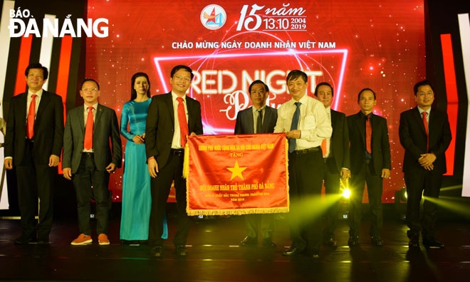 Thừa ủy quyền của Thủ tướng Chính phủ, Phó Chủ tịch Thường trực UBND thành phố Đặng Việt Dũng trao tặng cờ thi đua của Chính phủ cho Hội Doanh nhân trẻ thành phố Đà Nẵng đã hoàn thành xuất sắc, toàn diện nhiệm vụ công tác, dẫn đầu công tác thi đua năm 2018. Ảnh: KHÁNH HÒA