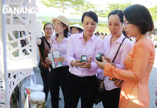 Chị Hoàng Thư (ngoài cùng, bên phải) đang giới thiệu các sản phẩm chế biến từ tảo đến khách hàng.