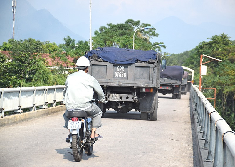 Xe tải chạy từng đoàn qua cầu Nông Sơn (huyện Nông Sơn) gây ách tắc giao thông và tiềm ẩn nguy cơ mất ATGT. Ảnh: T. THẮNG