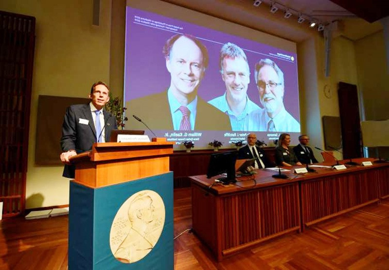 Hình ảnh ba nhà khoa học của giải Nobel Vật lý 2019 xuất hiện trên màn hình trong buổi lễ công bố giải thưởng của Ủy ban Nobel tại Thụy Điển. Ảnh: Gettyimage