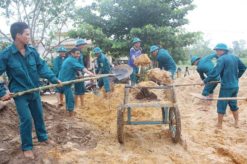 Lực lượng dân quân giúp dân làm đường giao thông nông thôn. Ảnh: T.A