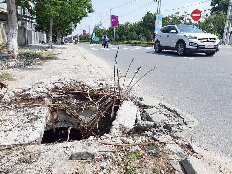 Nắp đậy hố ga trên vỉa hè đường ven biển qua phường Điện Dương (Điện Bàn) bị hư hỏng chưa được thay thế.