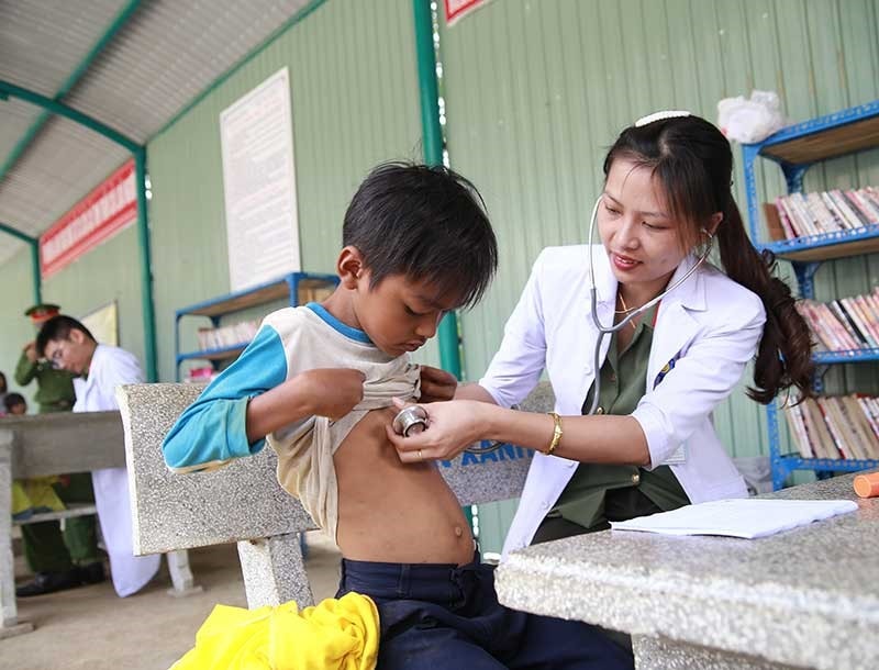 Đoàn viên Đoàn Thanh niên Công an tỉnh khám sức khỏe miễn phí cho các em học sinh. Ảnh: H.M