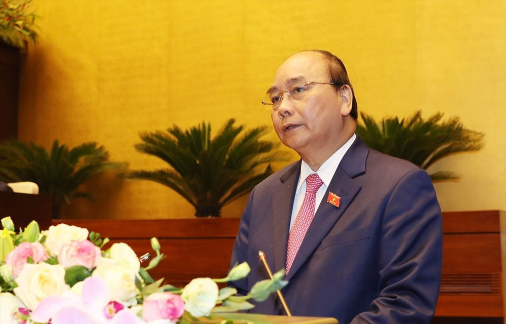 Thủ tướng Nguyễn Xuân Phúc đọc báo cáo của Chính phủ tại kỳ họp. Ảnh: TTXVN