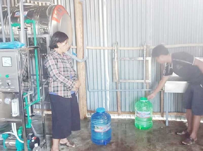 Người dân lấy nước từ hệ thống máy lọc nước về sử dụng. Ảnh: H.T