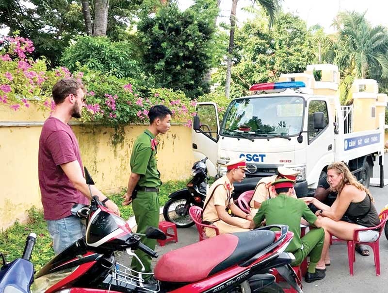 Công an TP.Hội An giải thích vi phạm của một du khách nước ngoài. Ảnh: CÔNG TUẤN