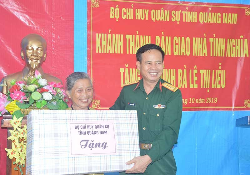 Đại tá Hứa Văn Tưởng - Chỉ huy trưởng Bộ CHQS tỉnh tặng quà bà Lê Thị Liễu. Ảnh: TUẤN ANH