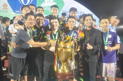 Các cầu thủ Hà Nội chụp ảnh lưu niệm với người thân cùng chiếc cúp vô địch. Ảnh: T.V