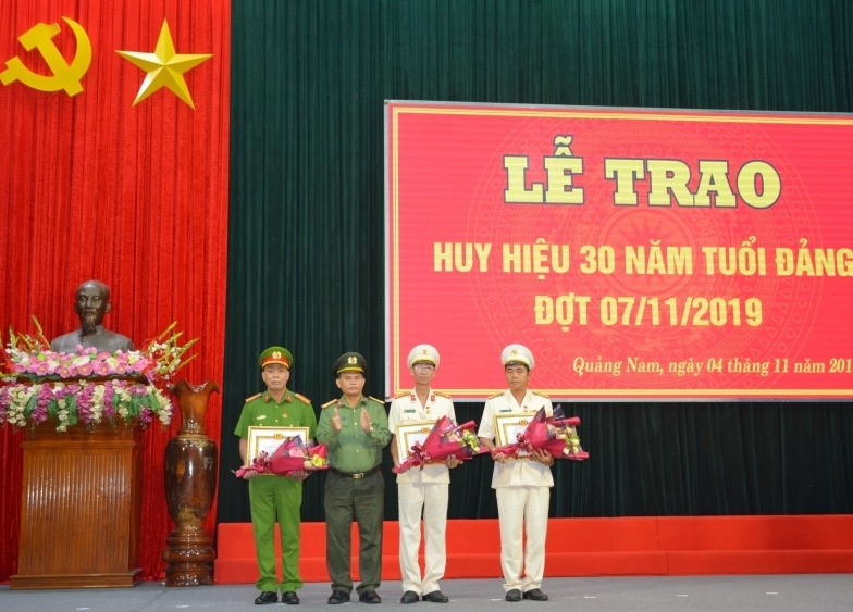 Đại tá Huỳnh Sông Thu - Phó Bí thư Đảng ủy, Phó Giám đốc Công an tỉnh trao Huy hiệu 30 năm tuổi Đảng cho 3 đảng viên. Ảnh: C.V