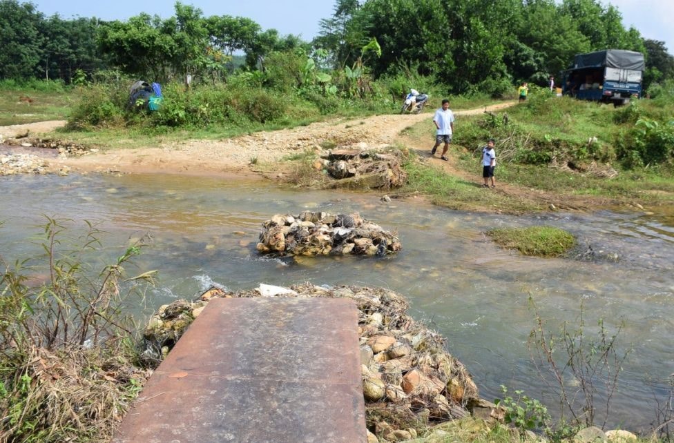 Nước cuốn trôi chiếc cầu tạm bắc qua suối Jơ Ron, chỉ còn lại các rọ đá. Ảnh: L.T