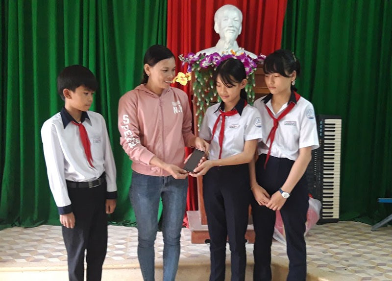 Ba học sinh trả lại chiếc điện thoại nhặt được cho chị Lâm Thị Sen. Ảnh: ÁNH TUYẾT