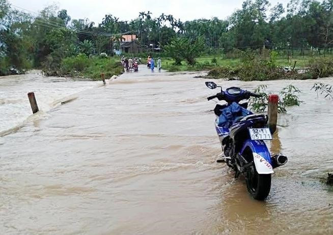 Nước lũ băng qua đường ĐX từ thôn 3 về trung tâm xã Trà Giang, cắt đứt lưu thông (ảnh chụp sáng 11.11). Ảnh: BÌNH NGUYỄN