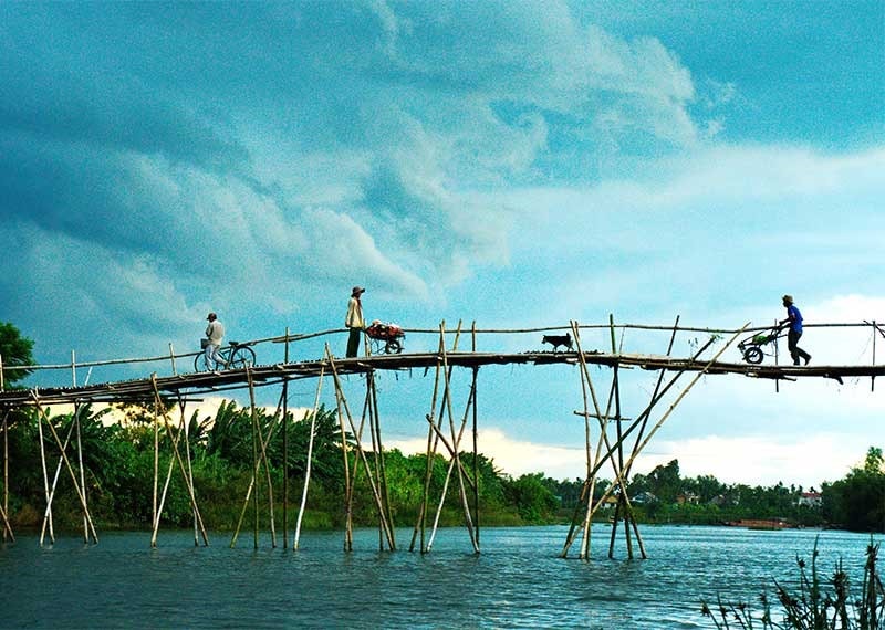 Vận chuyển rau màu về nhà bằng chiếc cầu tre nhưng nay đã bị nước lũ cuốn trôi. Ảnh: N.Đ.NGỌC