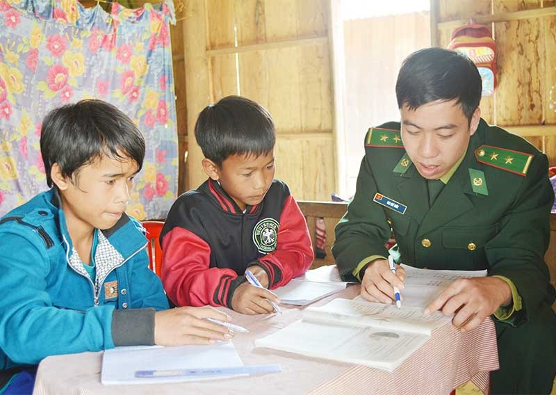 Cán bộ, chiến sĩ Bộ đội biên phòng Quảng Nam giúp đỡ học sinh ôn luyện kiến thức. Ảnh: HỒNG ANH