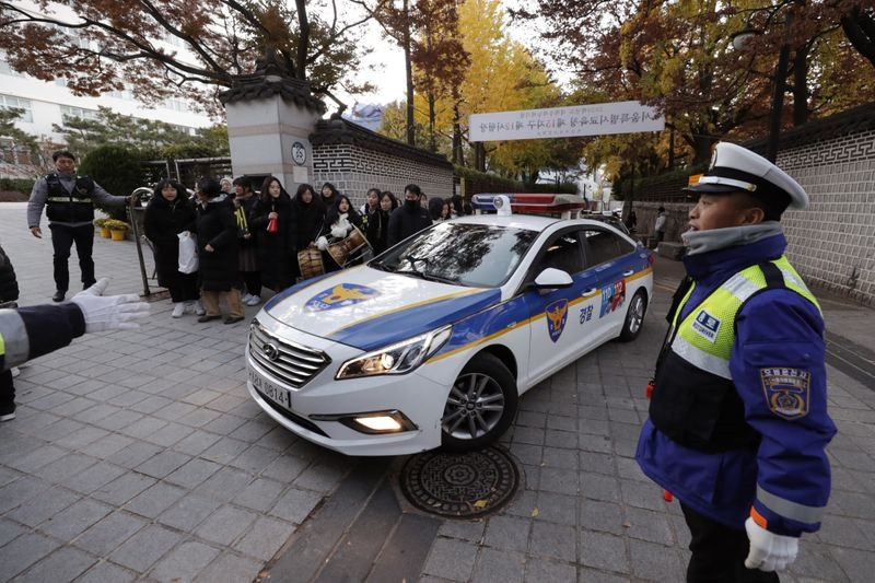 Cảnh sát giữ an ninh trật tự tại các điểm thi. Trong khi đó, các văn phòng chính phủ, doanh nghiệp và thậm chí thị trường chứng khoán của Seoul mở cửa muộn hơn một giờ so với bình thường, tức đến 10 giờ sáng. Ảnh: AP