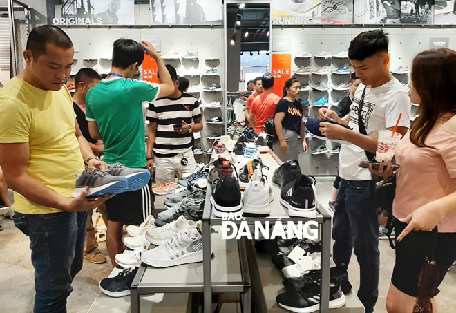 Nhiều bạn trẻ tìm đến các cửa hàng thời trang để “săn hàng giá rẻ”. Trong ảnh: Mua sắm tại cửa hàng của thương hiệu Charles&Keith số 56B đường Lê Duẩn.