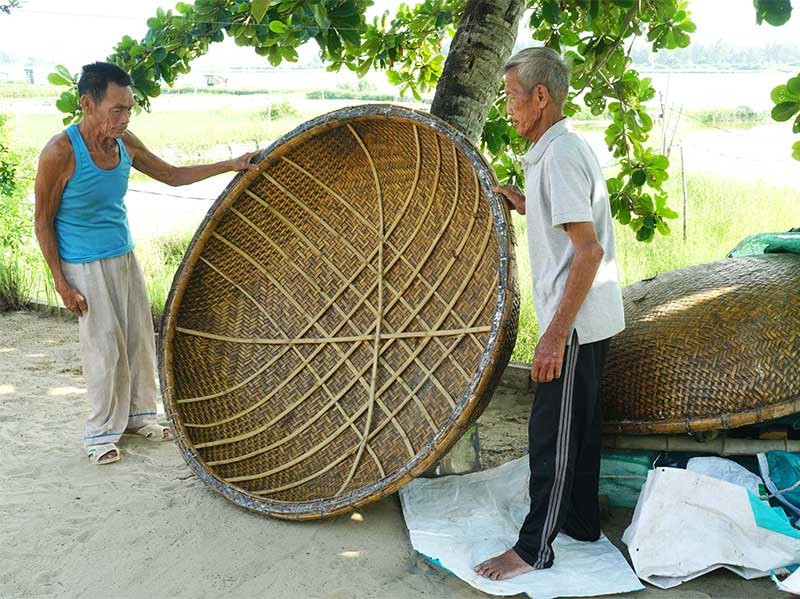 Ông Võ Luôn - Chủ nhiệm CLB đan tre Tam Thanh (bên trái) kiểm tra chất lượng sản phẩm thúng tròn trước khi giao hàng. Ảnh: N.Đ.N