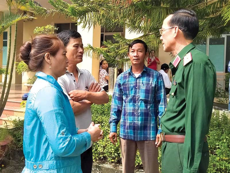 Thiếu tướng Nguyễn Đình Tiến trao đổi với các hộ tiểu thương bên ngoài cuộc đối thoại. Ảnh: N.Đ