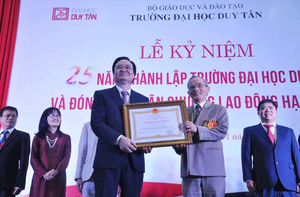 Bộ trưởng Bộ GD-ĐT Phùng Xuân Nhạ (trái) trao Huân chương Lao động hạng Nhất cho Trường Đại học Duy Tân. Ảnh: N.T.B