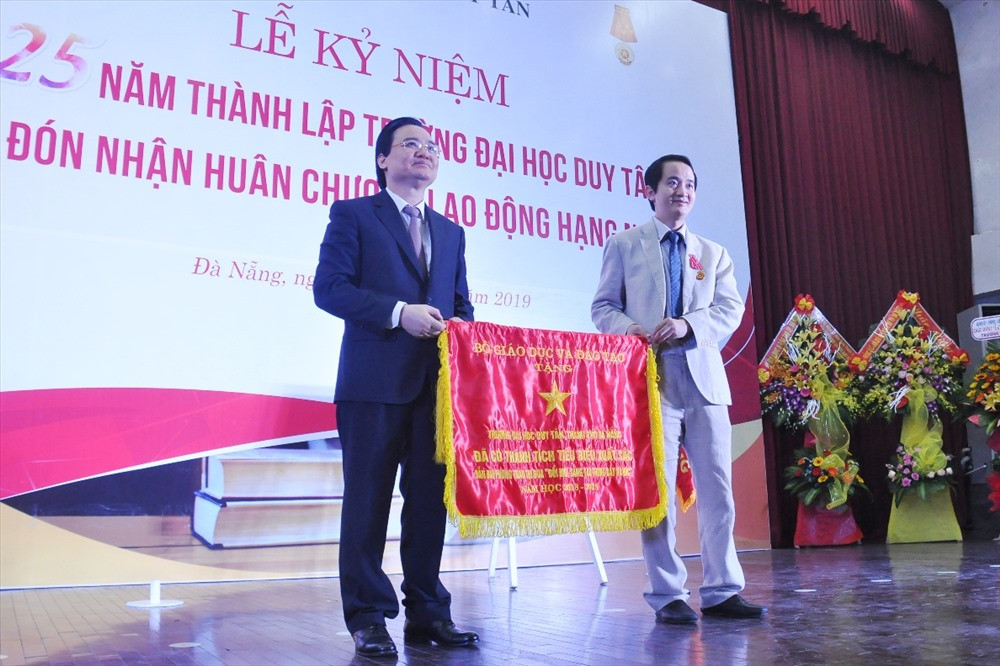 Bộ trưởng Phùng Xuân Nhạ trao Cờ dẫn đầu phong trào thi đua đổi mới sáng tạo trong dạy và học năm học 2018 - 2019 cho Trường Đại học Duy Tân. Ảnh: N.T.B