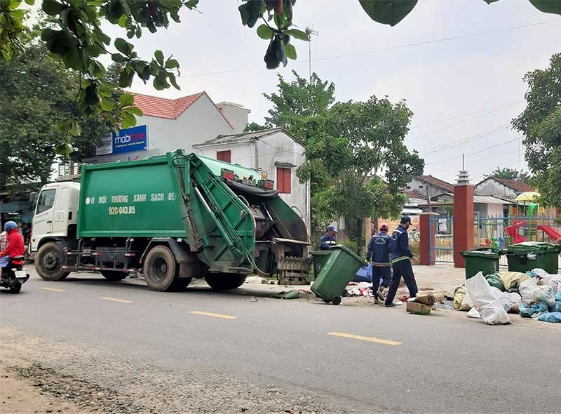 Công nhân Công ty CP Môi trường đô thị Quảng Nam thu gom rác tồn đọng tại xã Tam Dân, huyện Phú Ninh. Ảnh: THANH THẮNG