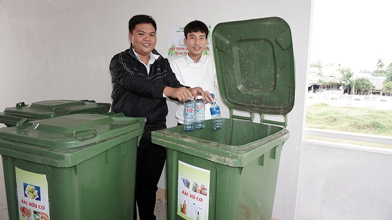 Học sinh Trường THPT Hồ Nghinh phân loại rác tại trường học. Ảnh: N.TRANG