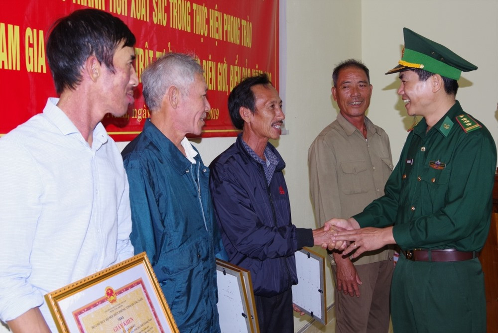 Thượng tá Hoàng Văn Mẫn - Chính ủy BĐBP tỉnh thăm hỏi, tuyên dương tinh thần tự giác của 5 người dân xã Tam Thanh. Ảnh: VĂN VINH