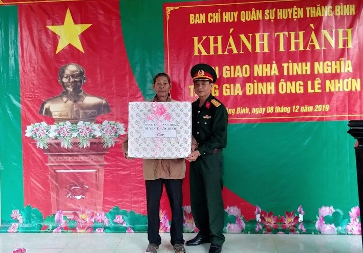 Ban CHQS huyện Thăng Bình tặng quà gia đình ông Lê Nhơn tại lễ bàn giao nhà. Ảnh: TOÀN HÀ