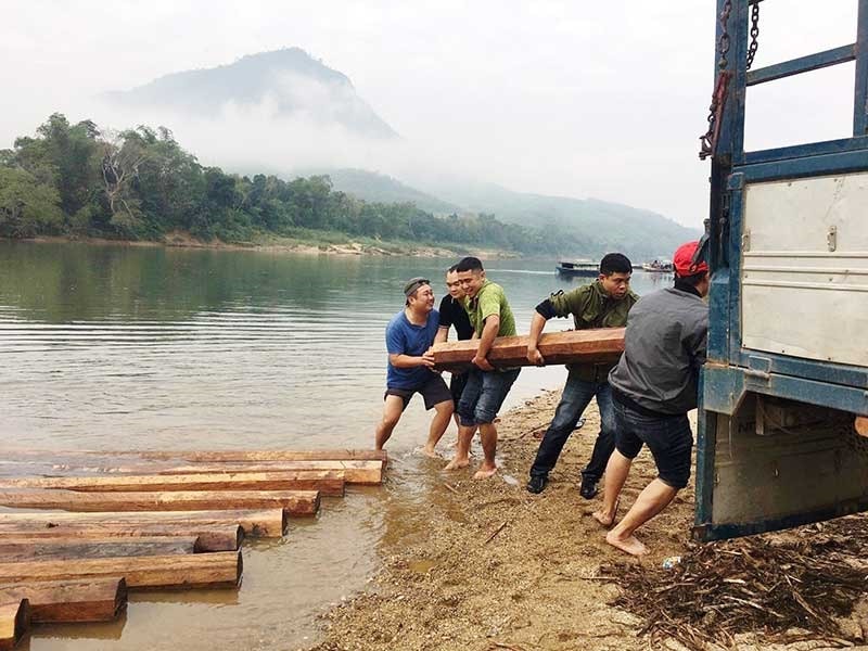 Cán bộ chiến sĩ Phòng Cảnh sát đường thủy trục vớt gỗ tang vật sau vụ phát hiện vận chuyển gỗ trái phép ngày 11.12.2019. Ảnh: C.A