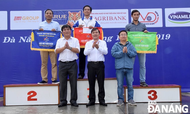 Tổng Biên tập Báo Đà Nẵng Nguyễn Đức Nam, Trưởng Ban tổ chức giải (giữa), Phó Tổng Biên tập Báo Đà Nẵng Hứa Văn Hải (phải) và Phó Giám đốc Sở VH-TT Nguyễn Trọng Thao (trái) tặng cờ cho 3 đơn vị giành giải thưởng toàn đoàn khối THPT.                            Ảnh: ANH VŨ