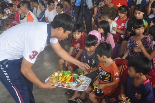 Trợ lý Dương Văn Tuyến tặng bánh kẹo cho trẻ em Làng Hòa Bình. Ảnh: T.V