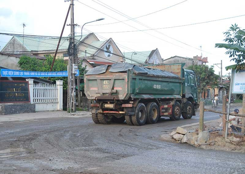 Xe chở cát trọng tải lớn gây hư hỏng mặt đường ĐT609, làm cảnh quan nhếch nhác ngay trước Trạm Y tế xã Đại Quang (Đại Lộc). Ảnh: N.B