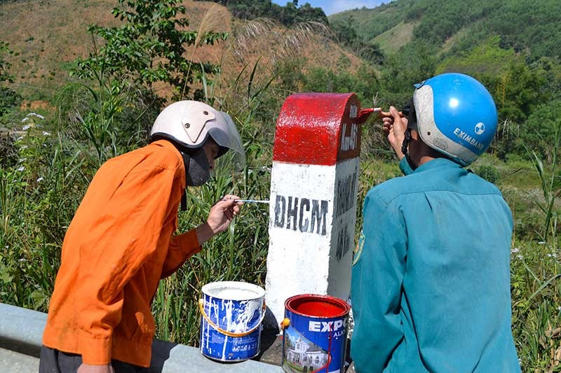 Đơn vị quản lý đường Hồ Chí Minh tiến hành sơn sửa lại cột ki lô mét, đoạn qua địa bàn huyện Đông Giang. Ảnh: CÔNG TÚ