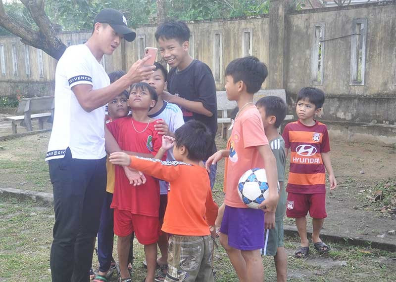 Cầu thủ Hà Minh Tuấn chia sẻ hình ảnh chụp cùng trẻ em Làng Hòa Bình. Ảnh: T.V