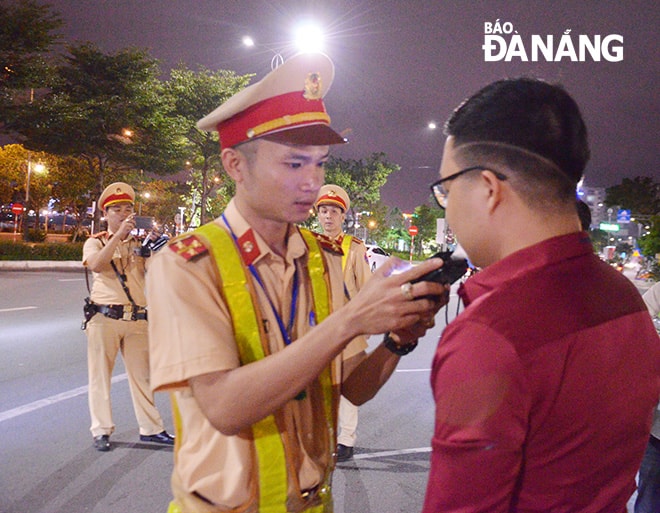 Tài xế chấp hành hiệu lệnh và thổi vào ống đo nồng độ cồn của CSGT. 