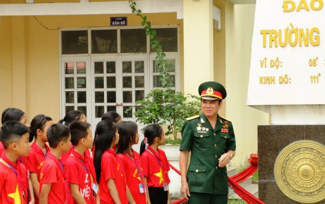 Học sinh trường THCS Kim Liên tham gia một buổi ngoại khóa bên mô hình cột mốc chủ quyền đảo Trường Sa tại sân trường.