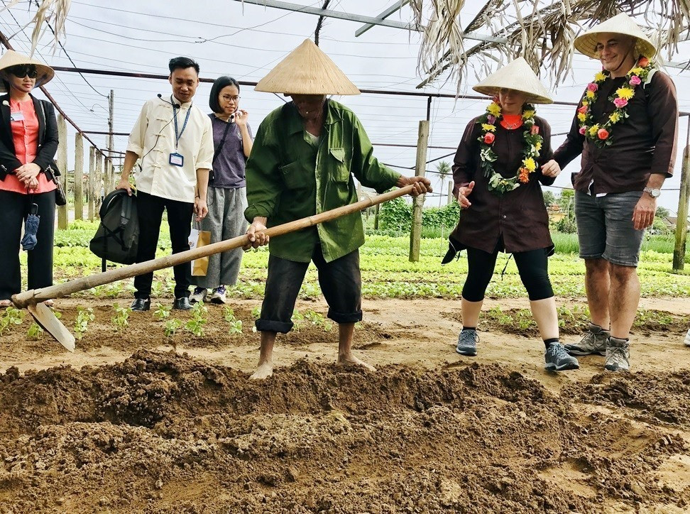 Visitors are interested in the villagers’ farm work.