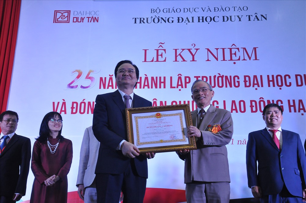 Bộ trưởng Bộ GD-ĐT Phùng Xuân Nhạ (trái) trao Huân chương Lao động hạng Nhất cho Trường Đại học Duy Tân tại lễ kỷ niệm 25 năm thành lập trường. Ảnh: T.B