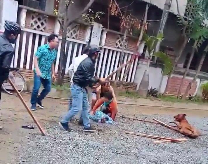 Người dân dùng gậy đập con chó để giải vây cho người phụ nữ. Ảnh: P.B