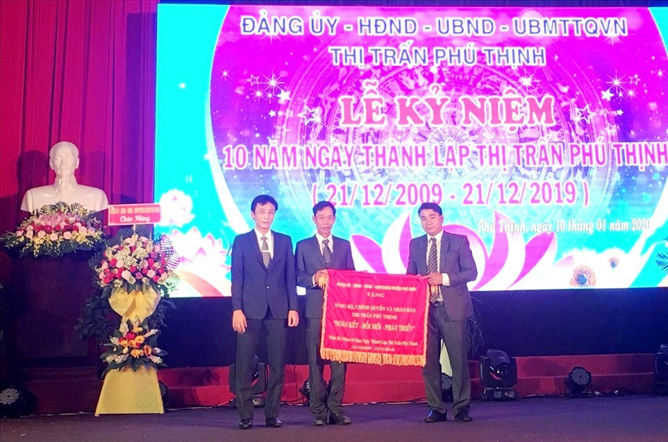 Ông Nguyễn Phi Thạnh - Bí thư Huyện ủy, Chủ tịch UBND huyện Phú Ninh (ngoài cùng bên trái) tặng bức trướng cho lãnh đạo thị trấn Phú Thịnh. Ảnh: H.C