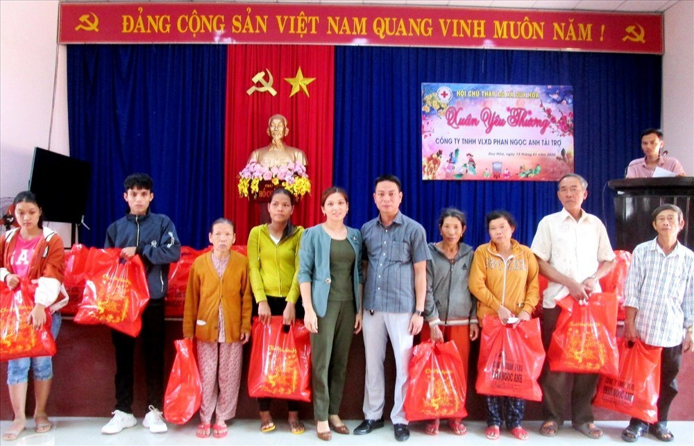 Đại diện lãnh đạo Công ty TNHH Vật liệu xây dựng Phan Ngọc Anh tặng quà cho người dân xã Duy Hòa. Ảnh: HOÀI NHI