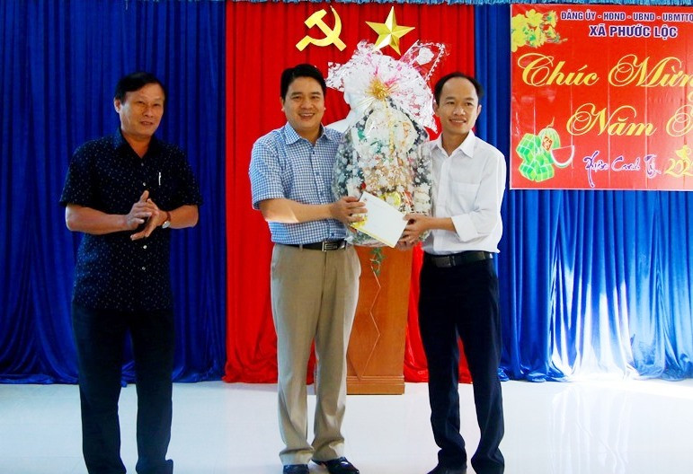 Đồng chí Trần Văn Tân tặng quà UBND xã Phước Lộc. Ảnh: T.C